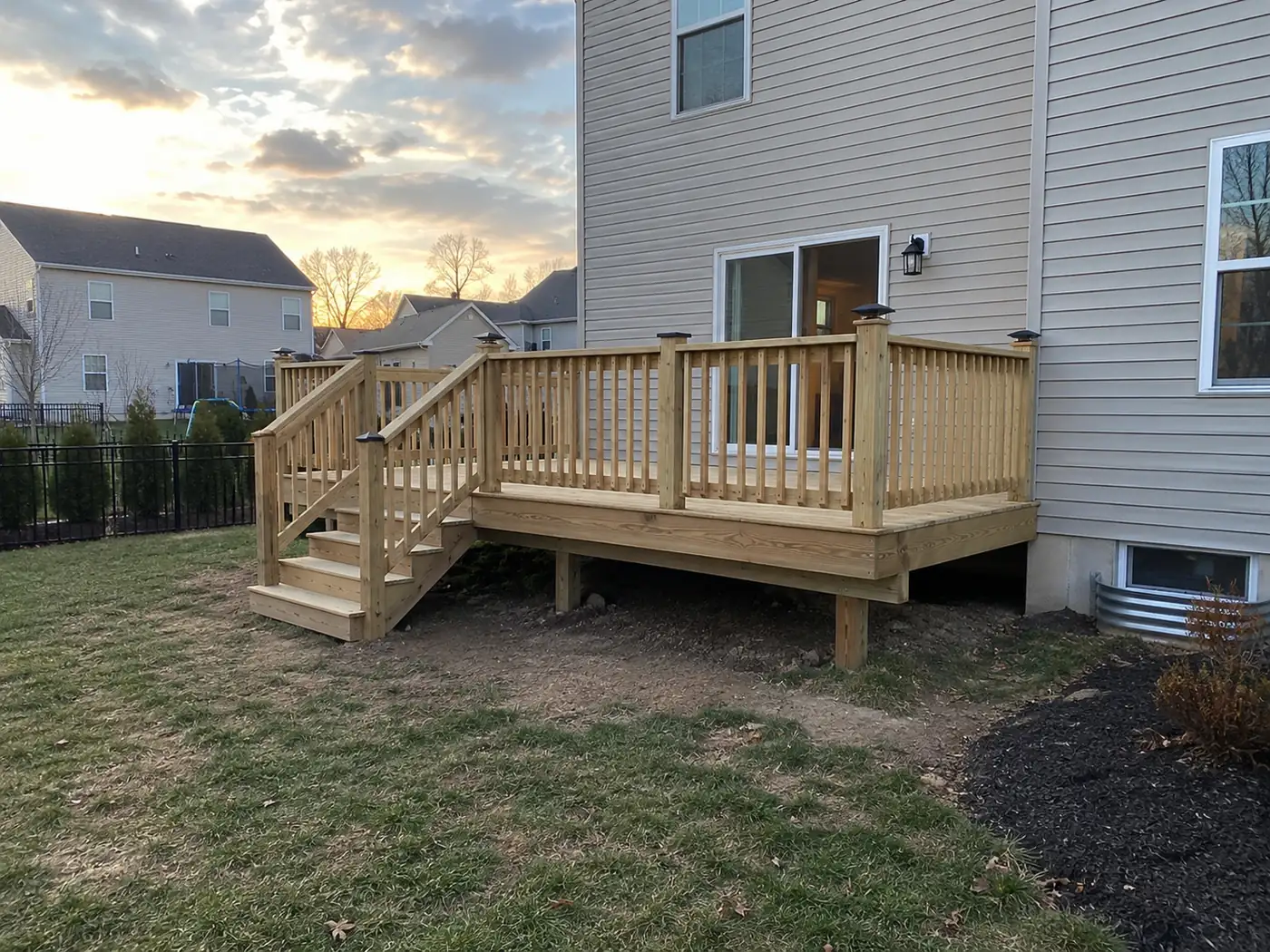 Concept rendering: wood deck at sunset with stairs beside a siding home in Wilmington, DE